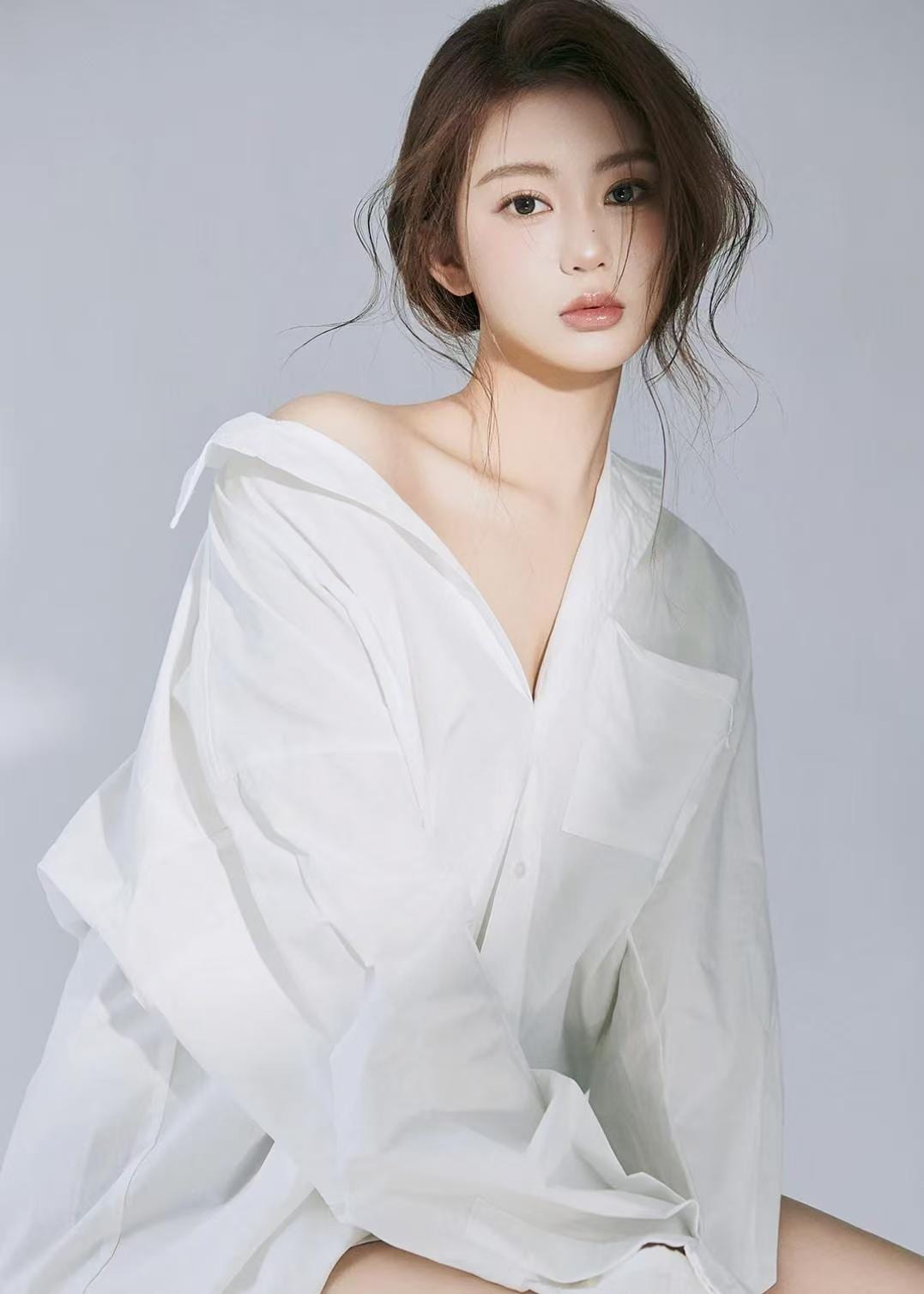 K9 Studio portrait in an oversized white shirt, soft neutral studio background