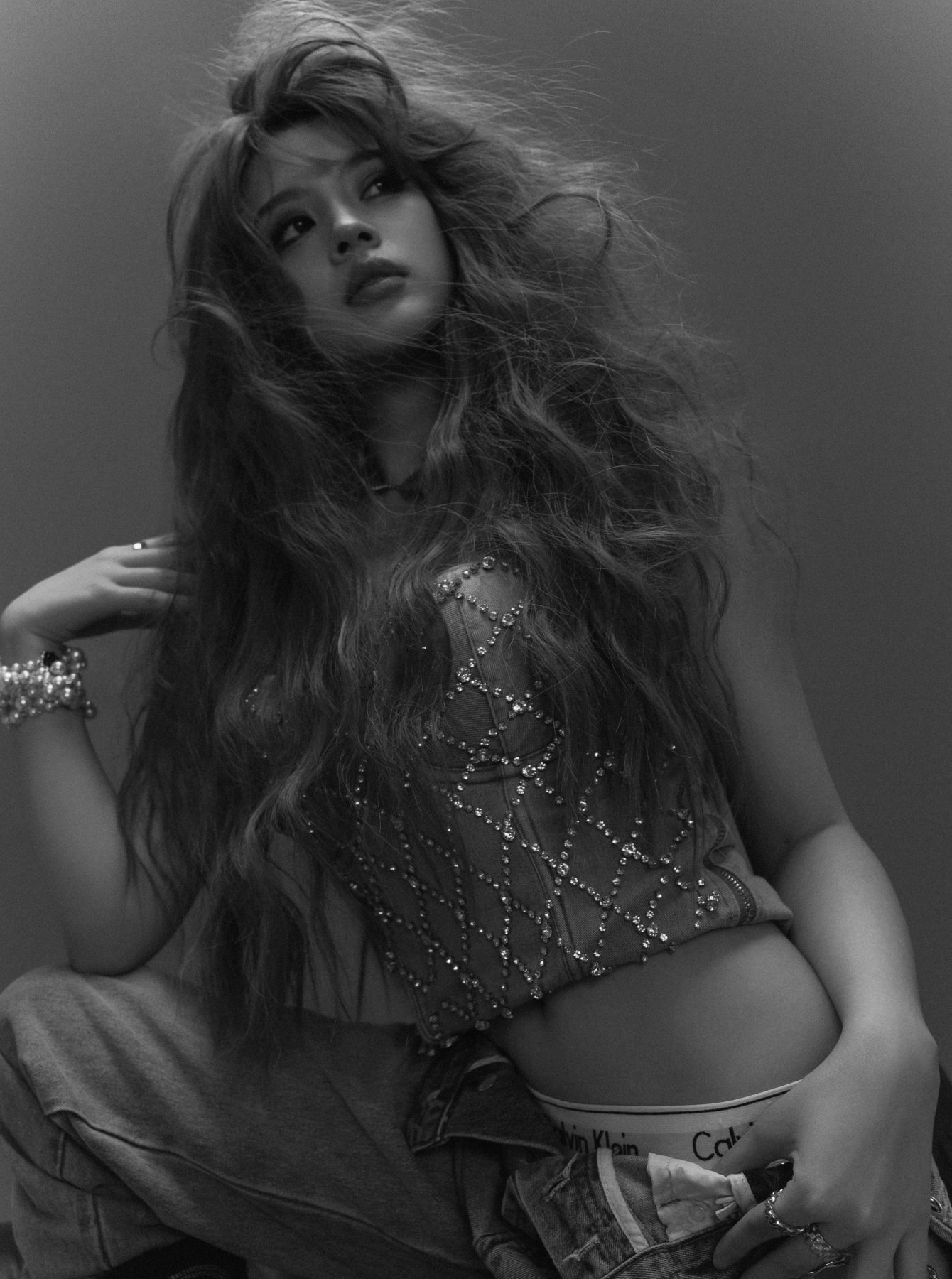 K9 Studio client black-and-white editorial portrait with voluminous wavy hair and a sparkling corset top