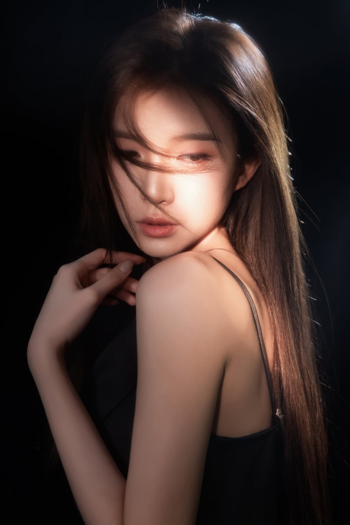 K9 Studio client portrait in a black v-neck dress, dramatic lighting, dark background