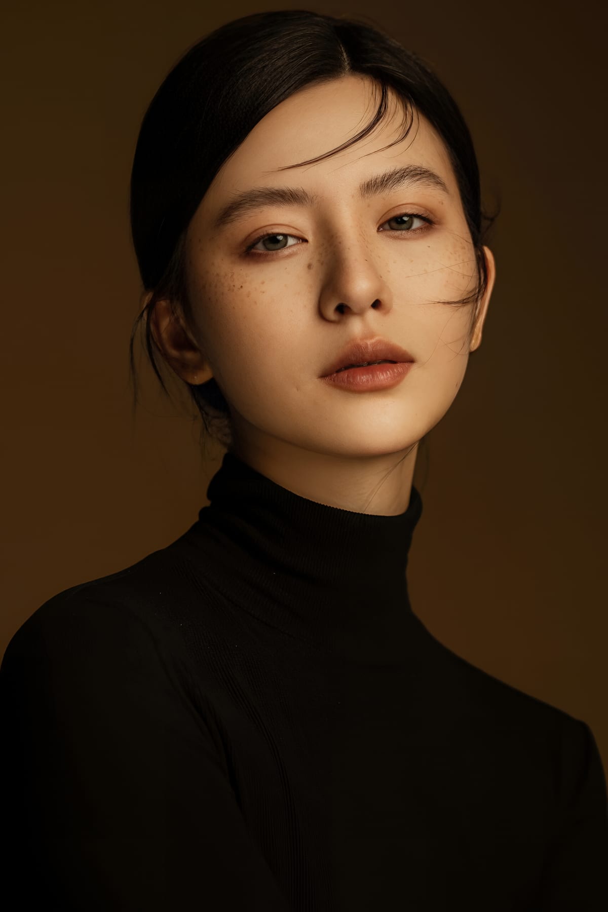 K9 Studio client portrait in a black turtleneck, warm side lighting