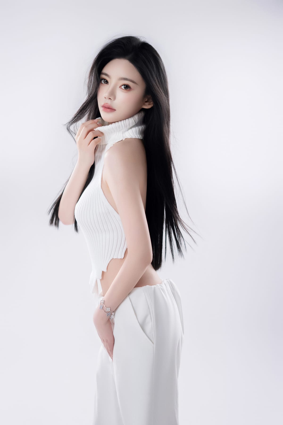 K9 Studio client side-profile portrait in a white ribbed halter top and trousers, hand at the collar